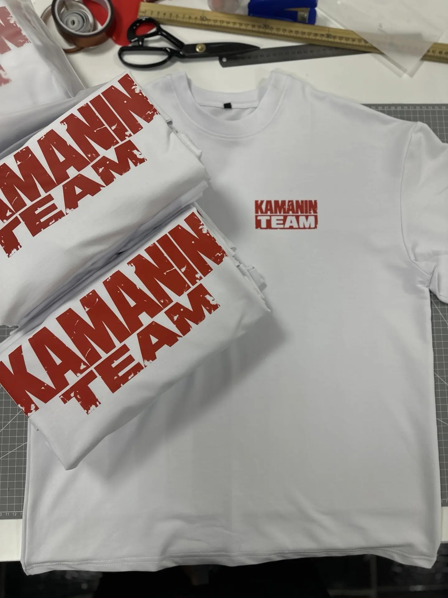 Белые футболки Kamanin Team с красной командной графикой